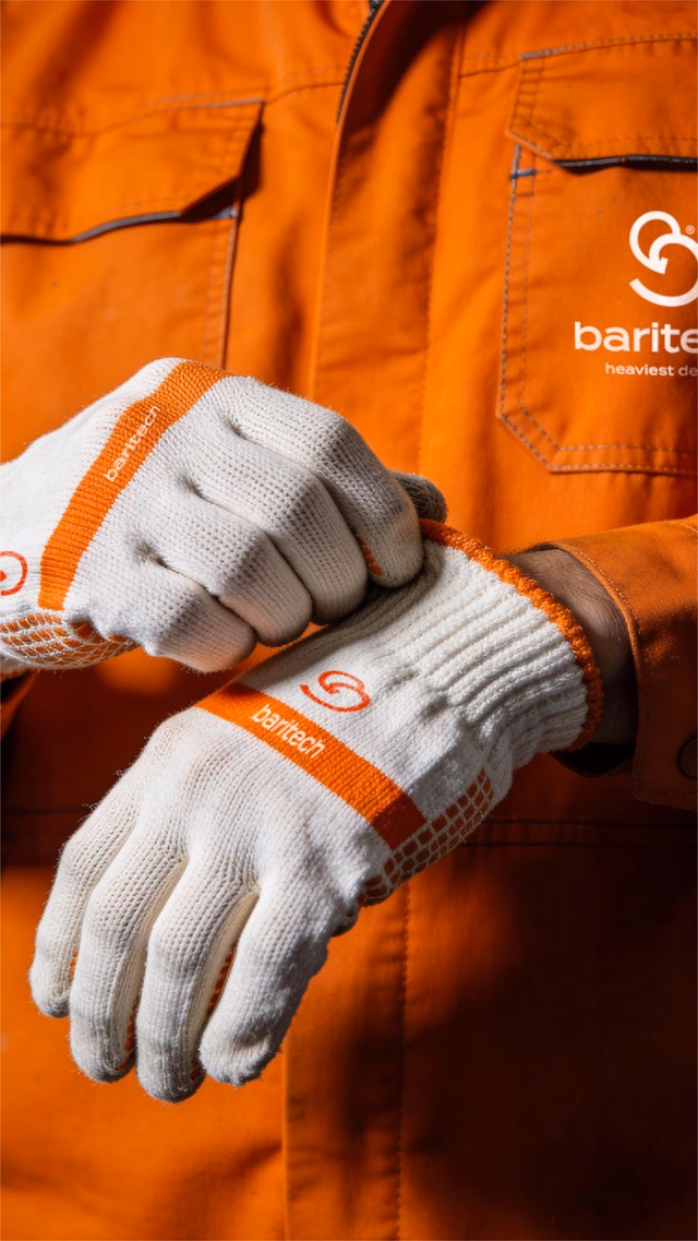 Close up of heavy duty work gloves and an orange branded coverall