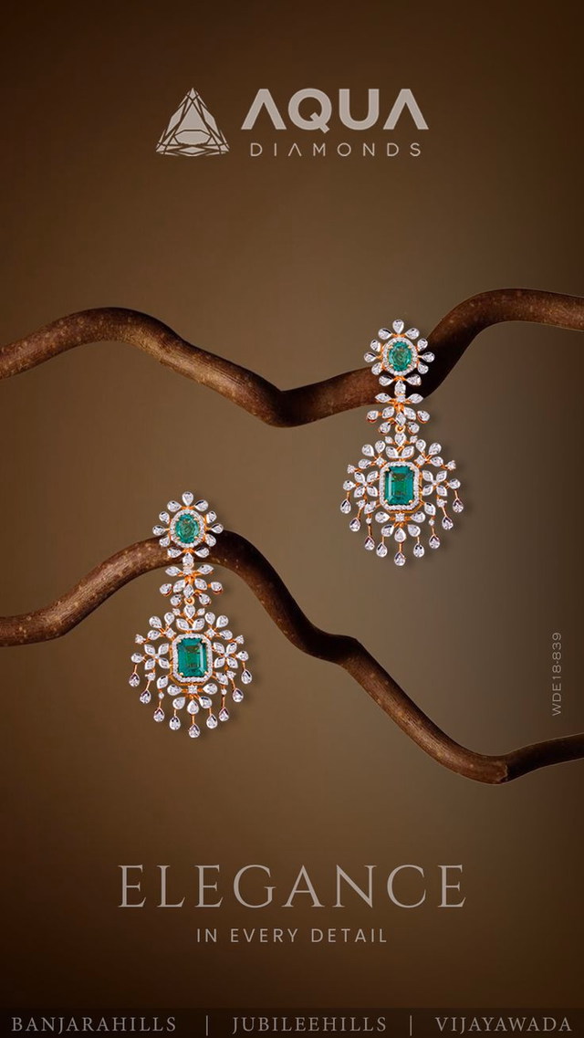 Aqua Diamonds emerald drop earrings styled on a branch with the line Elegance in every detail